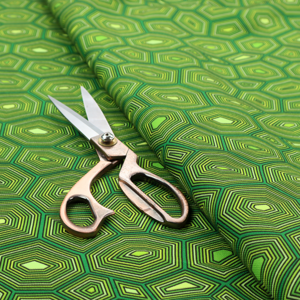 Seamless green fabric pattern featuring a detailed geometric print resembling a natural tortoise or sea turtle shell with concentric lines.
