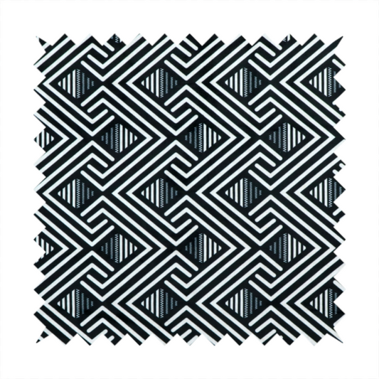 A geometric pattern featuring a repeating labyrinthine or Greek key-inspired design. The fabric has a high-contrast black and white colour scheme, with white interlocking lines forming diamond shapes and diagonal pathways against a deep black background.