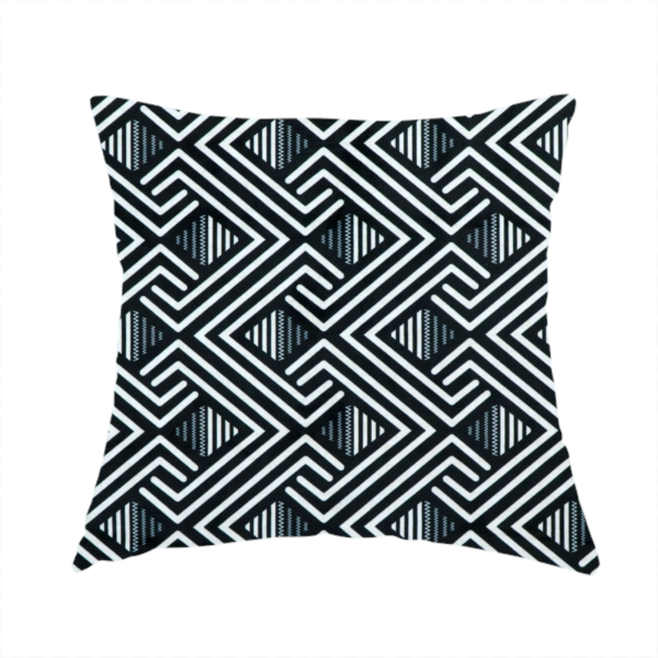 The fabric used to create this handmade cushion is a geometric pattern featuring a repeating labyrinthine or Greek key-inspired design. The fabric has a high-contrast black and white colour scheme, with white interlocking lines forming diamond shapes and diagonal pathways against a deep black background.