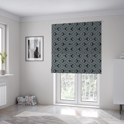 The fabric used to create these Roman blinds is a geometric pattern featuring a repeating labyrinthine or Greek key-inspired design. The fabric has a high-contrast black and white colour scheme, with white interlocking lines forming diamond shapes and diagonal pathways against a deep black background.