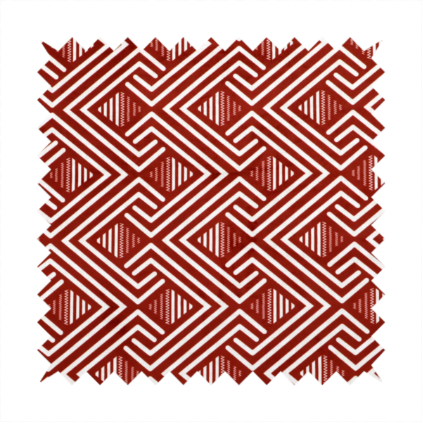 A bold geometric pattern featuring an interlocking labyrinth or fretwork design. The fabric is set in a striking terracotta red and cream colour palette, where crisp white lines weave together to form diagonal chains and diamond shapes against a rich, earthy red background.