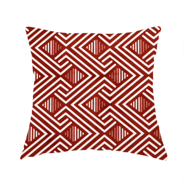 The fabric used to create this handmade cushion is a bold geometric pattern featuring an interlocking labyrinth or fretwork design. The fabric is set in a striking terracotta red and cream colour palette, where crisp white lines weave together to form diagonal chains and diamond shapes against a rich, earthy red background.