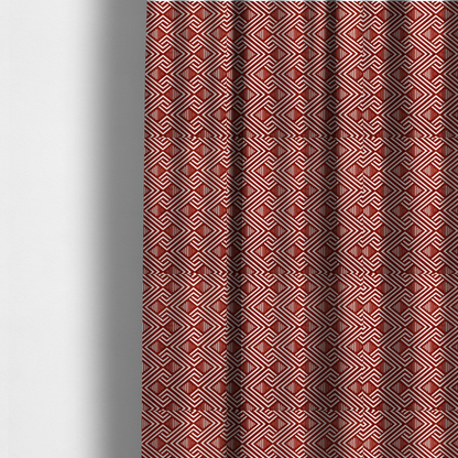 The fabric used to create these made-to-measure curtains is a bold geometric pattern featuring an interlocking labyrinth or fretwork design. The fabric is set in a striking terracotta red and cream colour palette, where crisp white lines weave together to form diagonal chains and diamond shapes against a rich, earthy red background.