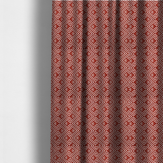 The fabric used to create these made-to-measure curtains is a bold geometric pattern featuring an interlocking labyrinth or fretwork design. The fabric is set in a striking terracotta red and cream colour palette, where crisp white lines weave together to form diagonal chains and diamond shapes against a rich, earthy red background.