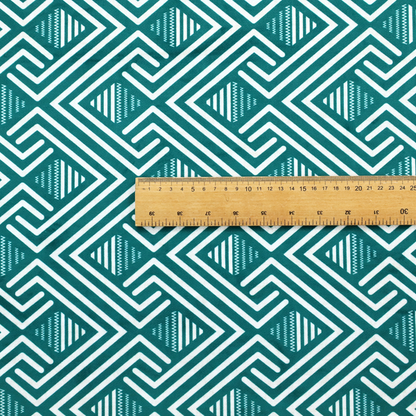 A striking geometric pattern featuring an interlocking labyrinth or fretwork motif. The fabric is set in a refreshing teal and white colour palette, with crisp white lines weaving together to form diagonal chains and diamond shapes against a rich, deep sea-green background.