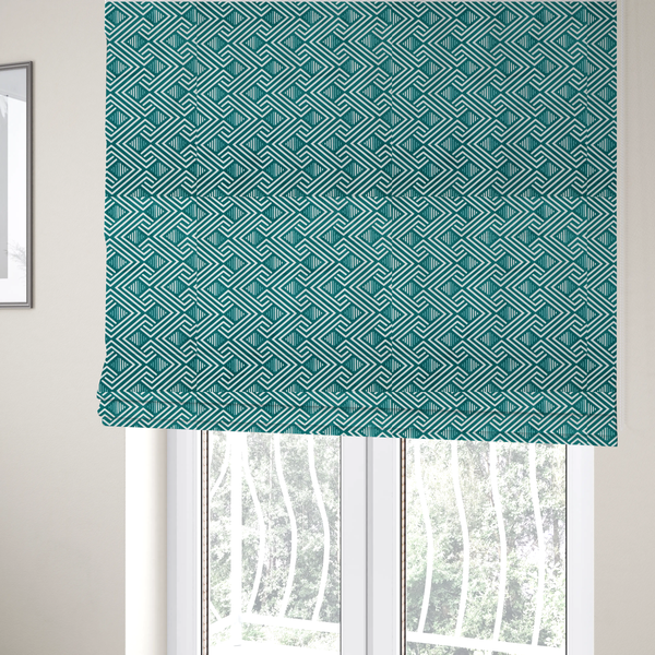 The fabric used to create these Roman blinds is a striking geometric pattern featuring an interlocking labyrinth or fretwork motif. The fabric is set in a refreshing teal and white colour palette, with crisp white lines weaving together to form diagonal chains and diamond shapes against a rich, deep sea-green background.