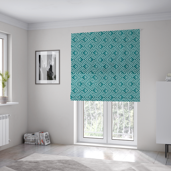 The fabric used to create these Roman blinds is a striking geometric pattern featuring an interlocking labyrinth or fretwork motif. The fabric is set in a refreshing teal and white colour palette, with crisp white lines weaving together to form diagonal chains and diamond shapes against a rich, deep sea-green background.