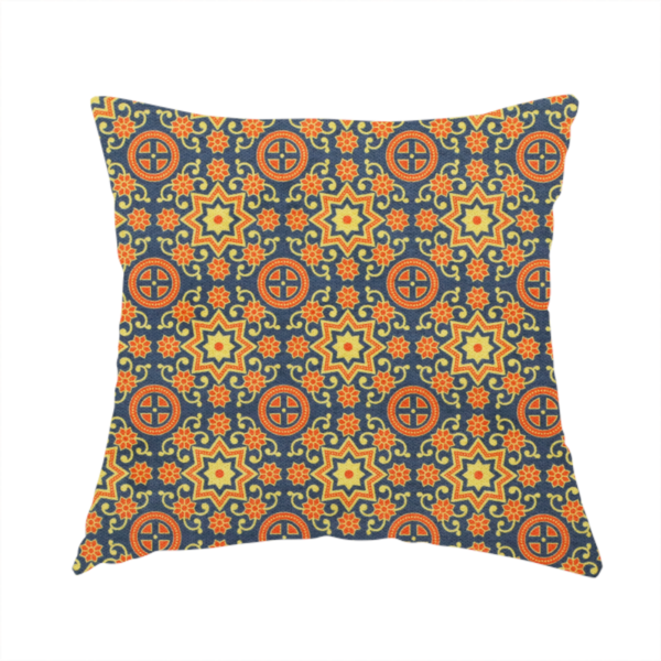 The fabric used to create this handmade cushion is a dense, symmetrical textile pattern featuring a repeating grid of pale yellow eight-pointed stars and orange circular medallions. The motifs are interconnected by delicate orange scrolling vines and tiny floral accents, set against a deep navy blue background. The colour palette consists of mustard yellow, burnt orange, and indigo.