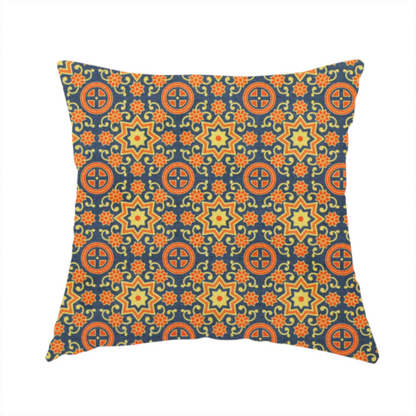 The fabric used to create this handmade cushion is a dense, symmetrical textile pattern featuring a repeating grid of pale yellow eight-pointed stars and orange circular medallions. The motifs are interconnected by delicate orange scrolling vines and tiny floral accents, set against a deep navy blue background. The colour palette consists of mustard yellow, burnt orange, and indigo.