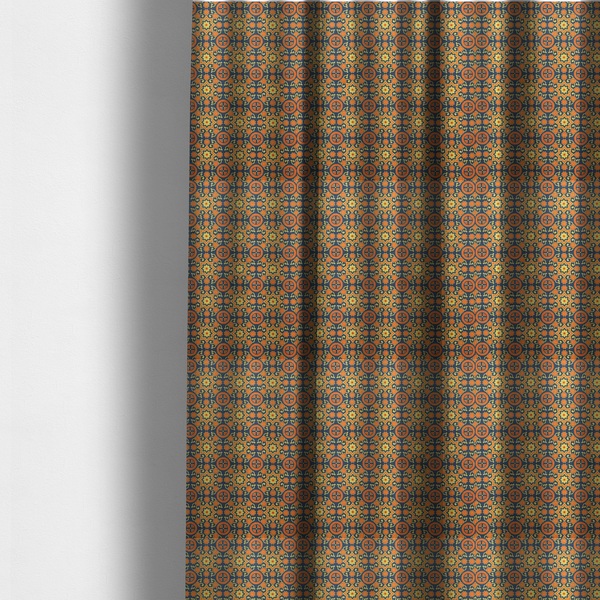 The fabric used to create these made-to-measure curtains is a dense, symmetrical textile pattern featuring a repeating grid of pale yellow eight-pointed stars and orange circular medallions. The motifs are interconnected by delicate orange scrolling vines and tiny floral accents, set against a deep navy blue background. The colour palette consists of mustard yellow, burnt orange, and indigo.