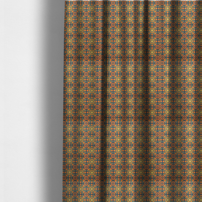 The fabric used to create these made-to-measure curtains is a dense, symmetrical textile pattern featuring a repeating grid of pale yellow eight-pointed stars and orange circular medallions. The motifs are interconnected by delicate orange scrolling vines and tiny floral accents, set against a deep navy blue background. The colour palette consists of mustard yellow, burnt orange, and indigo.