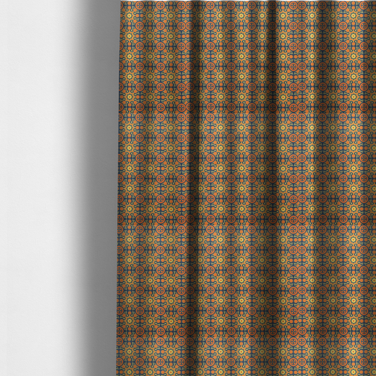 The fabric used to create these made-to-measure curtains is a dense, symmetrical textile pattern featuring a repeating grid of pale yellow eight-pointed stars and orange circular medallions. The motifs are interconnected by delicate orange scrolling vines and tiny floral accents, set against a deep navy blue background. The colour palette consists of mustard yellow, burnt orange, and indigo.