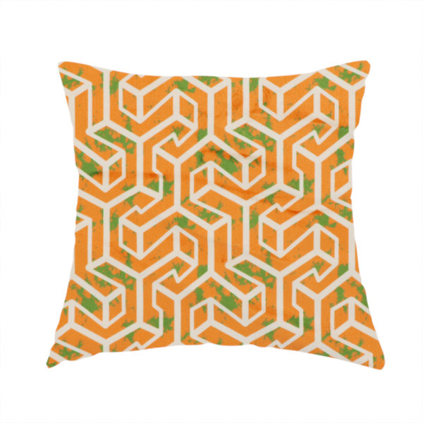 The fabric used to create this handmade cushion is an orange and white textile fabric featuring a repeating, interlocking geometric pattern. The design consists of white outlines that form three-dimensional, maze-like structures or isometric blocks against a vibrant orange background. A textured, green moss-like speckled effect is scattered across the orange spaces, adding an organic contrast to the sharp, structured geometric lines.