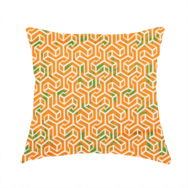 The fabric used to create this handmade cushion is a orange and white textile fabric featuring a smaller, densely repeating interlocking geometric pattern. The design consists of fine white outlines forming complex, three-dimensional isometric block structures on an orange background. Scattered green, moss-like textured speckles are integrated throughout, creating an organic, weathered look against the sharp geometry.
