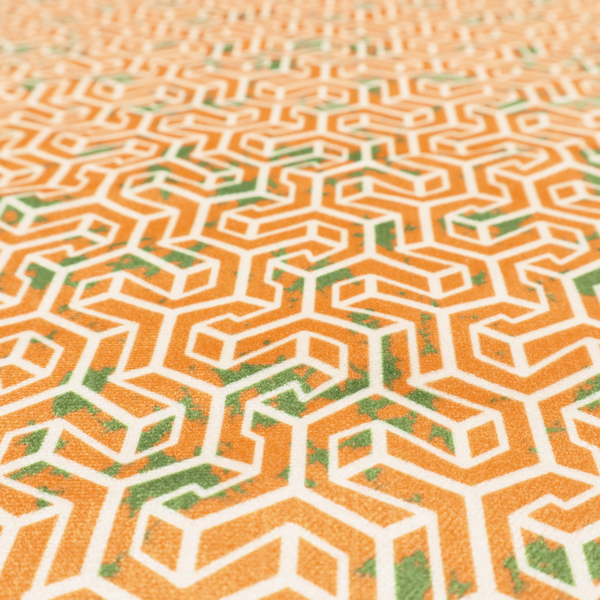 An orange and white textile fabric featuring a smaller, densely repeating interlocking geometric pattern. The design consists of fine white outlines forming complex, three-dimensional isometric block structures on an orange background. Scattered green, moss-like textured speckles are integrated throughout, creating an organic, weathered look against the sharp geometry.