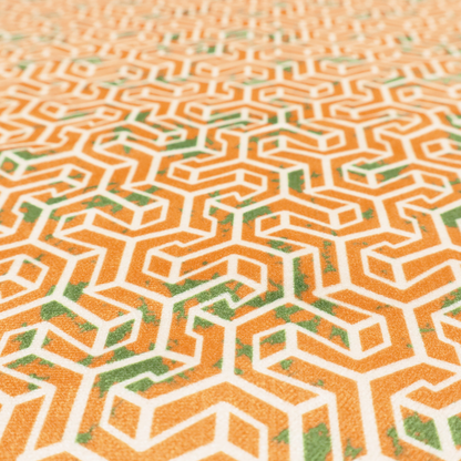 An orange and white textile fabric featuring a smaller, densely repeating interlocking geometric pattern. The design consists of fine white outlines forming complex, three-dimensional isometric block structures on an orange background. Scattered green, moss-like textured speckles are integrated throughout, creating an organic, weathered look against the sharp geometry.