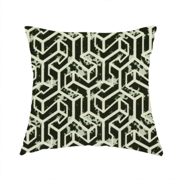 The fabric used to create this handmade cushion is a black and off-white textile fabric featuring a repeating, interlocking geometric pattern. The design consists of off-white outlines that form three-dimensional, isometric maze-like structures against a solid black background. Distressed, pale green speckled textures are subtly integrated into the background spaces, giving the sharp, structured design a weathered, organic touch.