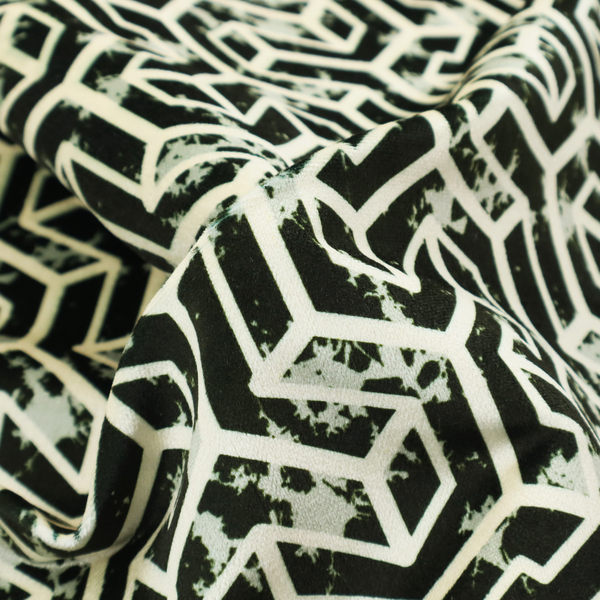 A black and off-white textile fabric featuring a repeating, interlocking geometric pattern. The design consists of off-white outlines that form three-dimensional, isometric maze-like structures against a solid black background. Distressed, pale green speckled textures are subtly integrated into the background spaces, giving the sharp, structured design a weathered, organic touch.