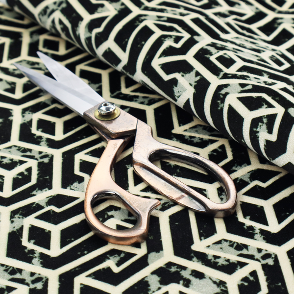 A black and off-white textile fabric featuring a repeating, interlocking geometric pattern. The design consists of off-white outlines that form three-dimensional, isometric maze-like structures against a solid black background. Distressed, pale green speckled textures are subtly integrated into the background spaces, giving the sharp, structured design a weathered, organic touch.
