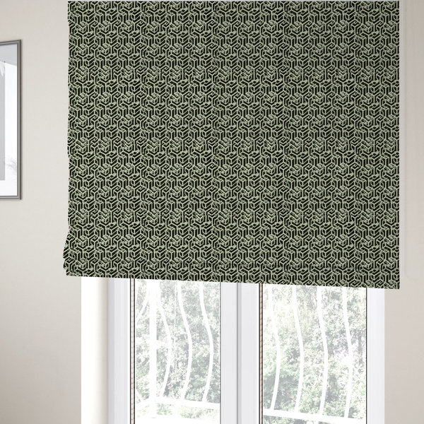 The fabric used to create these Roman blinds is a black and off-white textile fabric featuring a repeating, interlocking geometric pattern. The design consists of off-white outlines that form three-dimensional, isometric maze-like structures against a solid black background. Distressed, pale green speckled textures are subtly integrated into the background spaces, giving the sharp, structured design a weathered, organic touch.