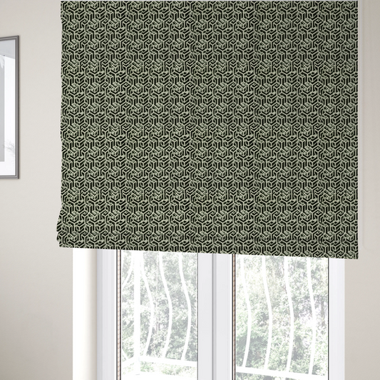 The fabric used to create these Roman blinds is a black and off-white textile fabric featuring a repeating, interlocking geometric pattern. The design consists of off-white outlines that form three-dimensional, isometric maze-like structures against a solid black background. Distressed, pale green speckled textures are subtly integrated into the background spaces, giving the sharp, structured design a weathered, organic touch.