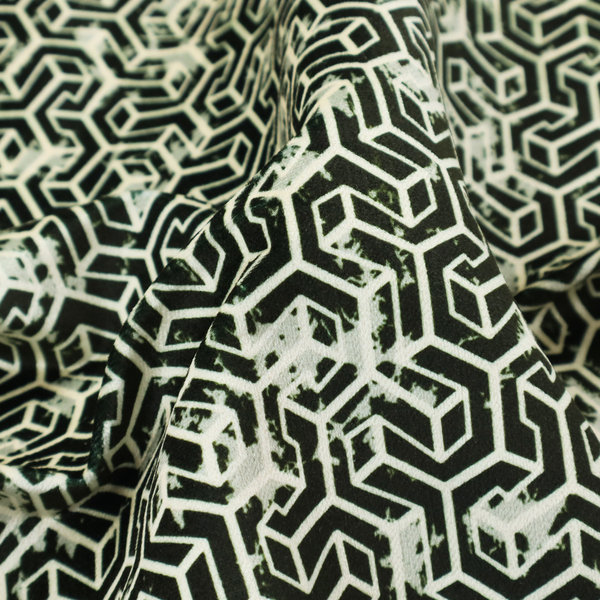 A black and off-white textile fabric featuring a small-scale, densely repeating interlocking geometric pattern. Fine off-white outlines construct complex, three-dimensional isometric block formations against a solid black background. Pale green, distressed textured speckles are integrated throughout, creating a weathered, organic contrast to the sharp geometric structure.