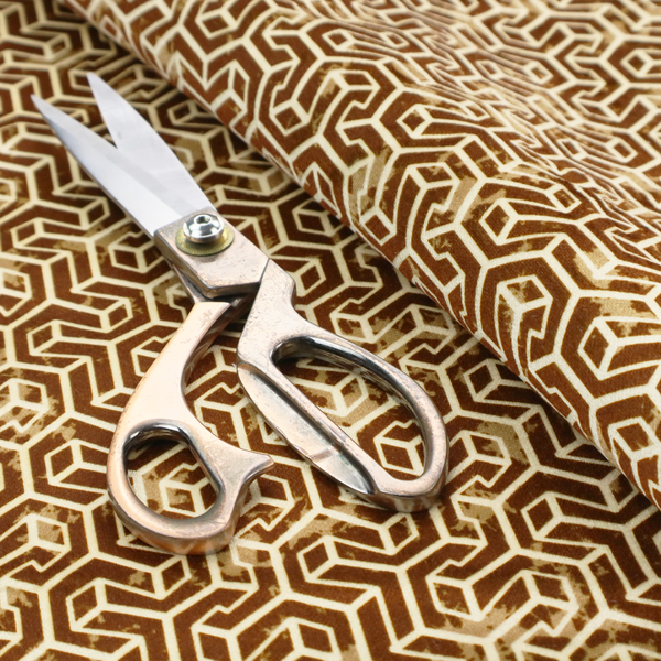 A brown and cream textile fabric featuring a small-scale, densely repeating interlocking geometric pattern. Fine cream-coloured outlines construct complex, three-dimensional isometric block formations against a warm, dark brown background. Lightly distressed, tan-speckled textures are integrated throughout, creating a weathered, organic contrast to the sharp geometric structure.