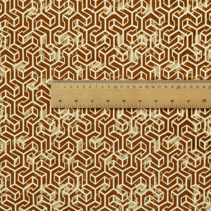 A brown and cream textile fabric featuring a small-scale, densely repeating interlocking geometric pattern. Fine cream-coloured outlines construct complex, three-dimensional isometric block formations against a warm, dark brown background. Lightly distressed, tan-speckled textures are integrated throughout, creating a weathered, organic contrast to the sharp geometric structure.