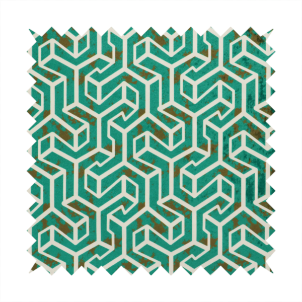 A teal and off-white textile fabric featuring a repeating, interlocking geometric pattern. The design consists of off-white outlines forming three-dimensional, isometric maze-like structures against a deep teal background. Distressed, brown speckled textures are subtly scattered throughout the teal spaces, giving the structured, geometric layout a weathered, organic touch.