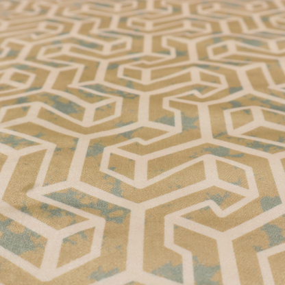 A beige and off-white textile fabric featuring a repeating, interlocking geometric pattern. The design consists of off-white outlines forming three-dimensional, isometric maze-like structures against a warm beige background. Distressed, pale green-blue speckled textures are subtly scattered throughout the beige spaces, giving the structured, geometric layout a weathered, organic touch.