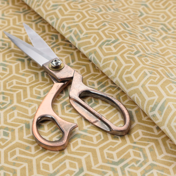 A beige and off-white textile fabric featuring a small-scale, densely repeating interlocking geometric pattern. Fine off-white outlines construct complex, three-dimensional isometric block formations against a warm beige background. Distressed, pale green-blue speckled textures are integrated throughout, creating a weathered, organic contrast to the sharp geometric structure.