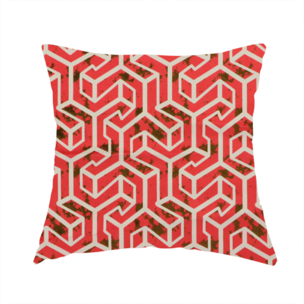 The fabric used to create this handmade cushion is a red and off-white textile fabric featuring a repeating, interlocking geometric pattern. The design consists of off-white outlines forming three-dimensional, isometric maze-like structures against a vibrant coral red background. Distressed, dark brown speckled textures are subtly scattered throughout the red spaces, adding a weathered, organic touch to the structured, geometric design.