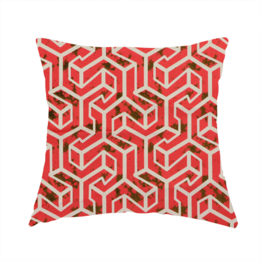 The fabric used to create this handmade cushion is a red and off-white textile fabric featuring a repeating, interlocking geometric pattern. The design consists of off-white outlines forming three-dimensional, isometric maze-like structures against a vibrant coral red background. Distressed, dark brown speckled textures are subtly scattered throughout the red spaces, adding a weathered, organic touch to the structured, geometric design.