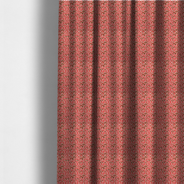 The fabric used to create these made-to-measure curtains is a red and off-white textile fabric featuring a repeating, interlocking geometric pattern. The design consists of off-white outlines forming three-dimensional, isometric maze-like structures against a vibrant coral red background. Distressed, dark brown speckled textures are subtly scattered throughout the red spaces, adding a weathered, organic touch to the structured, geometric design.