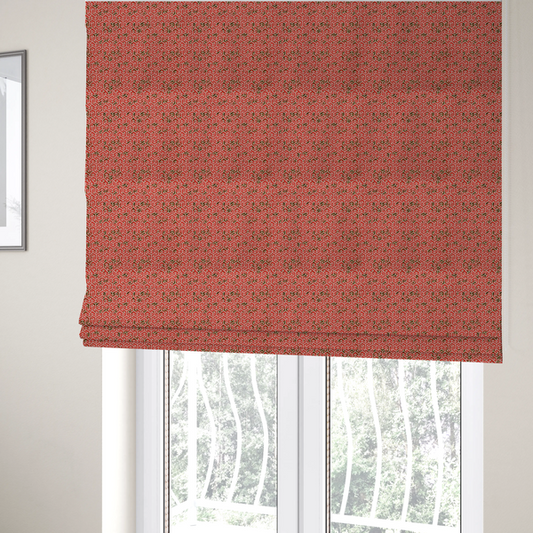 The fabric used to create these Roman blinds is a coral red and off-white textile fabric featuring a small-scale, densely repeating interlocking geometric pattern. Fine off-white outlines construct complex, three-dimensional isometric block formations against a vibrant coral red background. Distressed, dark brown speckled textures are integrated throughout, creating a weathered, organic contrast to the sharp geometric structure.