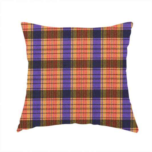 The fabric used to create this handmade cushion is a vibrant, multi-coloured plaid fabric featuring a complex grid of horizontal and vertical stripes. The pattern blends deep indigo, golden ochre, and olive green, highlighted by thin, high-contrast stripes of bright violet and coral pink.