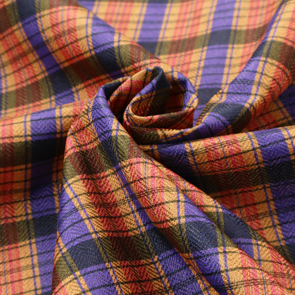 A vibrant, multi-coloured plaid fabric featuring a complex grid of horizontal and vertical stripes. The pattern blends deep indigo, golden ochre, and olive green, highlighted by thin, high-contrast stripes of bright violet and coral pink.