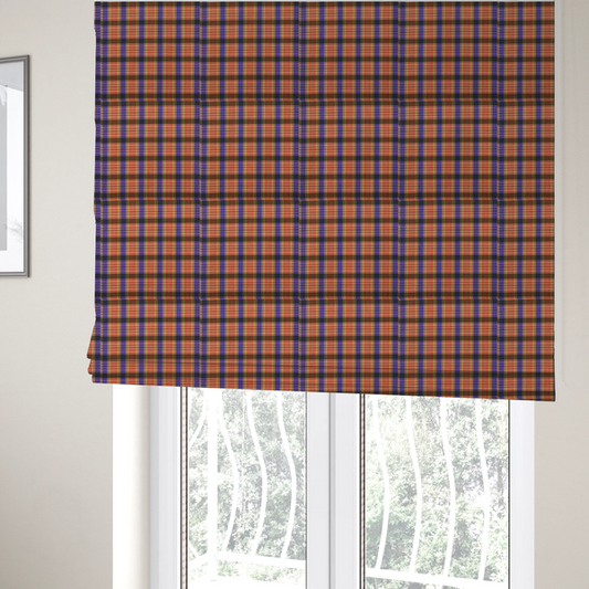 The fabric used to create these Roman blinds is a vibrant, multi-coloured plaid fabric featuring a complex grid of horizontal and vertical stripes. The pattern blends deep indigo, golden ochre, and olive green, highlighted by thin, high-contrast stripes of bright violet and coral pink.