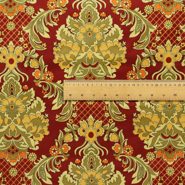 An ornate damask fabric featuring large, symmetrical floral medallions in shades of sage green, golden ochre, and muted orange.