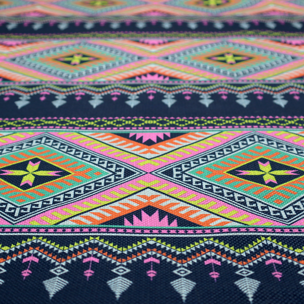 A vibrant, repeating geometric Aztec or tribal fabric pattern organized in horizontal bands. The design features alternating wide stripes of colourful diamond and zigzag motifs against narrower dark navy bands filled with intricate chevron and tassel-like embroidery accents.
