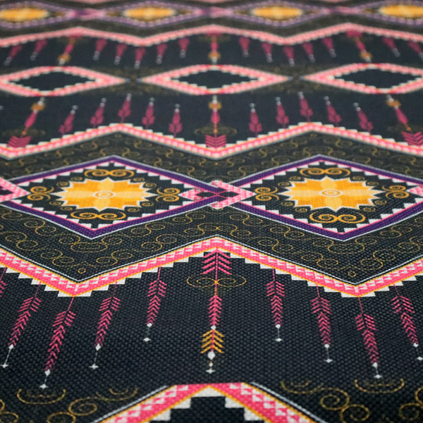 An intricate, repeating tribal fabric pattern set against a dark charcoal-black background, featuring horizontal bands of detailed geometric, ikat, and ornate line art motifs.