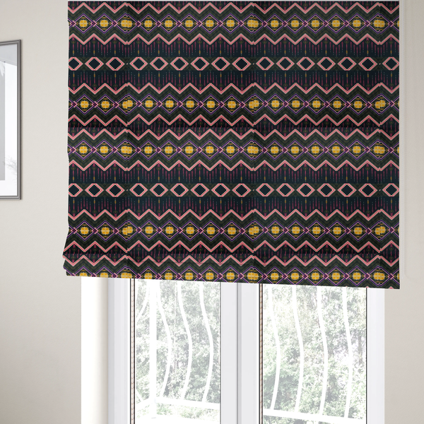 The fabric used to create these Roman blinds is a intricate, repeating tribal fabric pattern set against a dark charcoal-black background, featuring horizontal bands of detailed geometric, ikat, and ornate line art motifs.