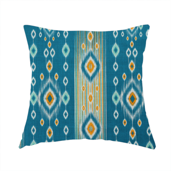 The fabric used to create this handmade cushion is a seamless, vertically striped ikat fabric pattern with traditional blurred or feathered edges set against a rich teal backdrop.