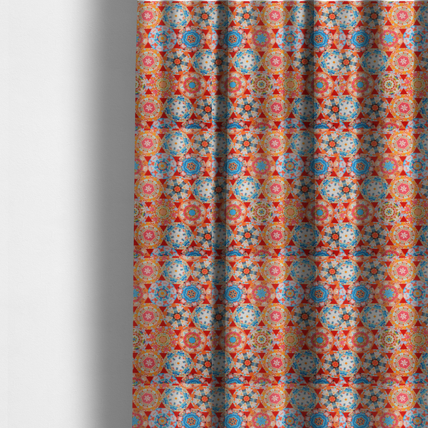 The fabric used to create these made-to-measure curtains is a vibrant, kaleidoscope-inspired fabric pattern composed of interlocking circular and octagonal medallions set against a rich, fiery red-orange background.