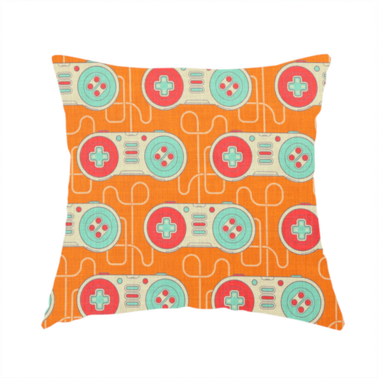 The fabric used to create this handmade cushion is a playful, retro-inspired repeating fabric pattern featuring classic video game controllers connected by winding cord lines set against a warm orange background.