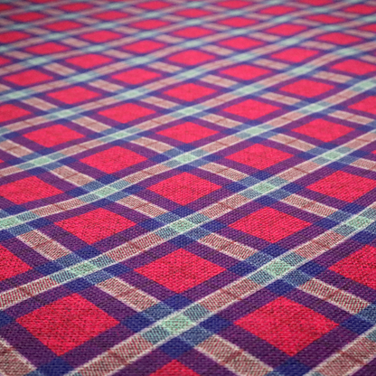 This fabric features a diagonal plaid pattern, creating a diamond-shaped grid. The design is composed of bold magenta squares framed by dark blue and thin white intersecting lines.