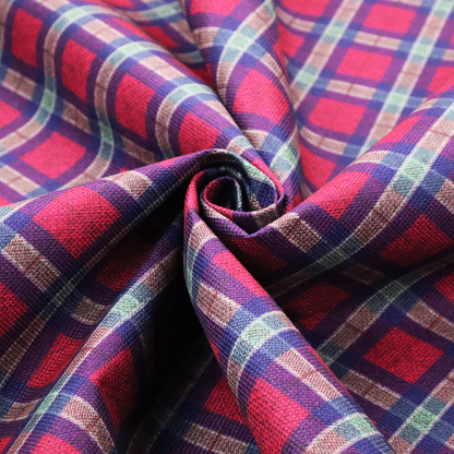 This fabric features a diagonal plaid pattern, creating a diamond-shaped grid. The design is composed of bold magenta squares framed by dark blue and thin white intersecting lines.