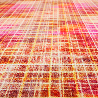 This fabric features an intricate, layered plaid pattern that blends warm tones of red, orange, yellow, and deep pink. The design has a slightly blurred, watercolour effect with a dense grid of fine white and gold lines overlapping the vibrant colours.