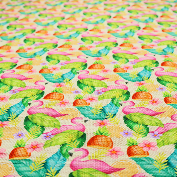 This fabric features a tropical pattern on a light, neutral background, densely decorated with illustrations of bright pink flamingos, pineapples, lush green tropical leaves, and small purple and pink flowers.