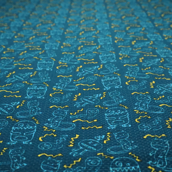 This fabric features a playful, dark teal background covered in a whimsical pattern of small, light blue line-art monsters and yellow zigzagging lightning bolt accents.